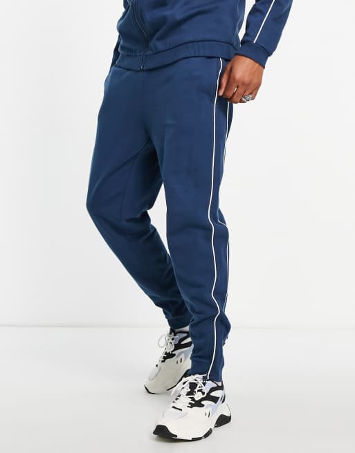 ASOS DESIGN tapered trackies with piping in navy (Part of a co-ord)