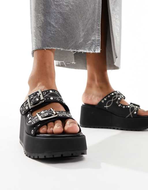 ASOS DESIGN Texas Mules in Schwarz mit Nietenbesatz Schnallendetail und Keilabsatz ASOS