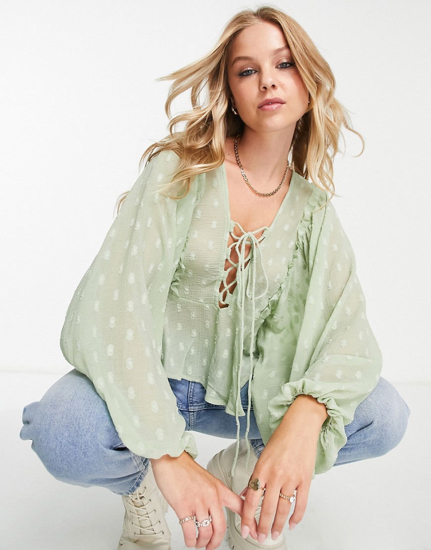 ASOS DESIGN textured long sleeve blouse with lace up front & peplum hem in sage-Green