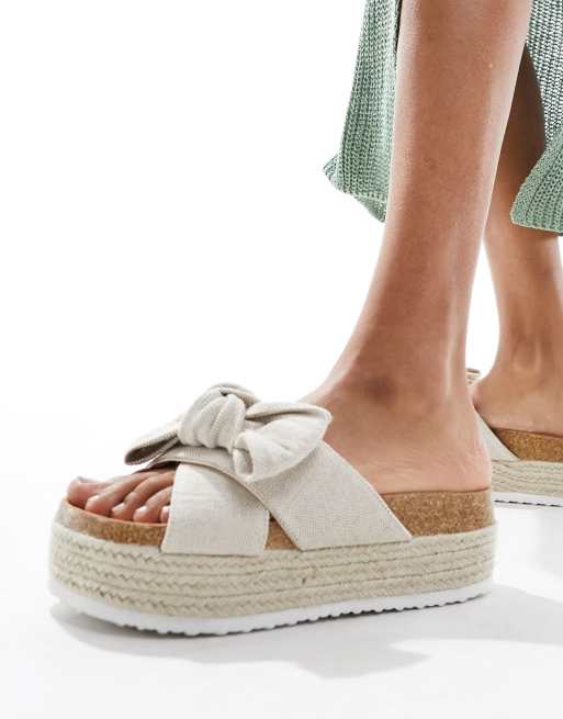 CerbeShops DESIGN – Thankful – Beiga flatform-sandaler i naturligt material med rosettdetalj