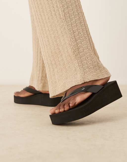 ASOS DESIGN – Tigerlily – Zehenstegsandalen in Schwarz mit Keilabsatz