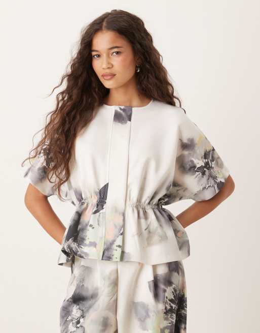 ASOS DESIGN - Top in tessuto effetto scuba stretto in vita con stampa a fiori in coordinato