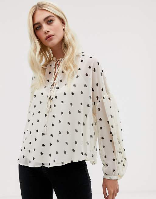 ASOS DESIGN - Top oversize a maniche lunghe annodato al collo con stampa a cuori