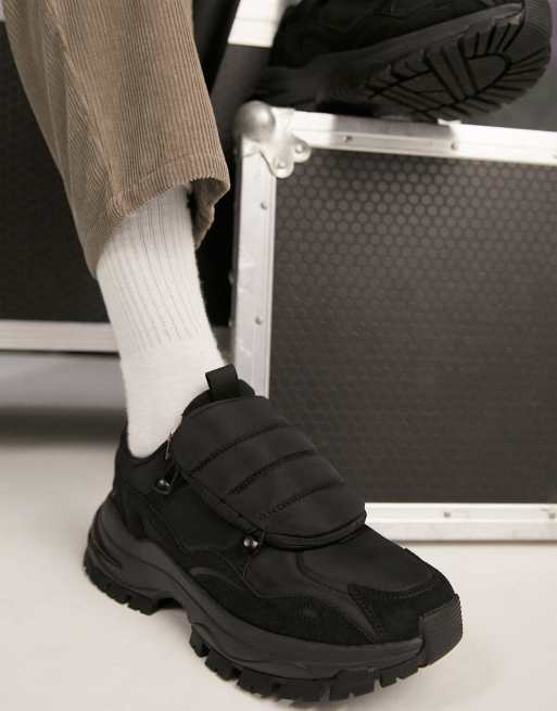 ASOS DESIGN trainers with tech details and padded bag in black