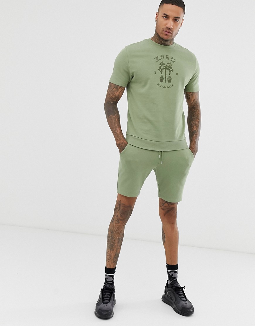 ASOS DESIGN - Tuta felpa a maniche corte/pantaloncini skinny e stampa sul petto tono su tono-Verde