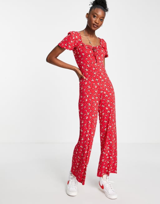 ASOS DESIGN - Tuta jumpsuit con laccetti, colore rosso con stampa a fiorellini 