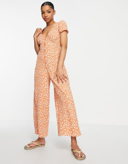 ASOS DESIGN - Tuta jumpsuit da giorno in crêpe arancione a fiori con bottoni sul davanti e maniche ad aletta