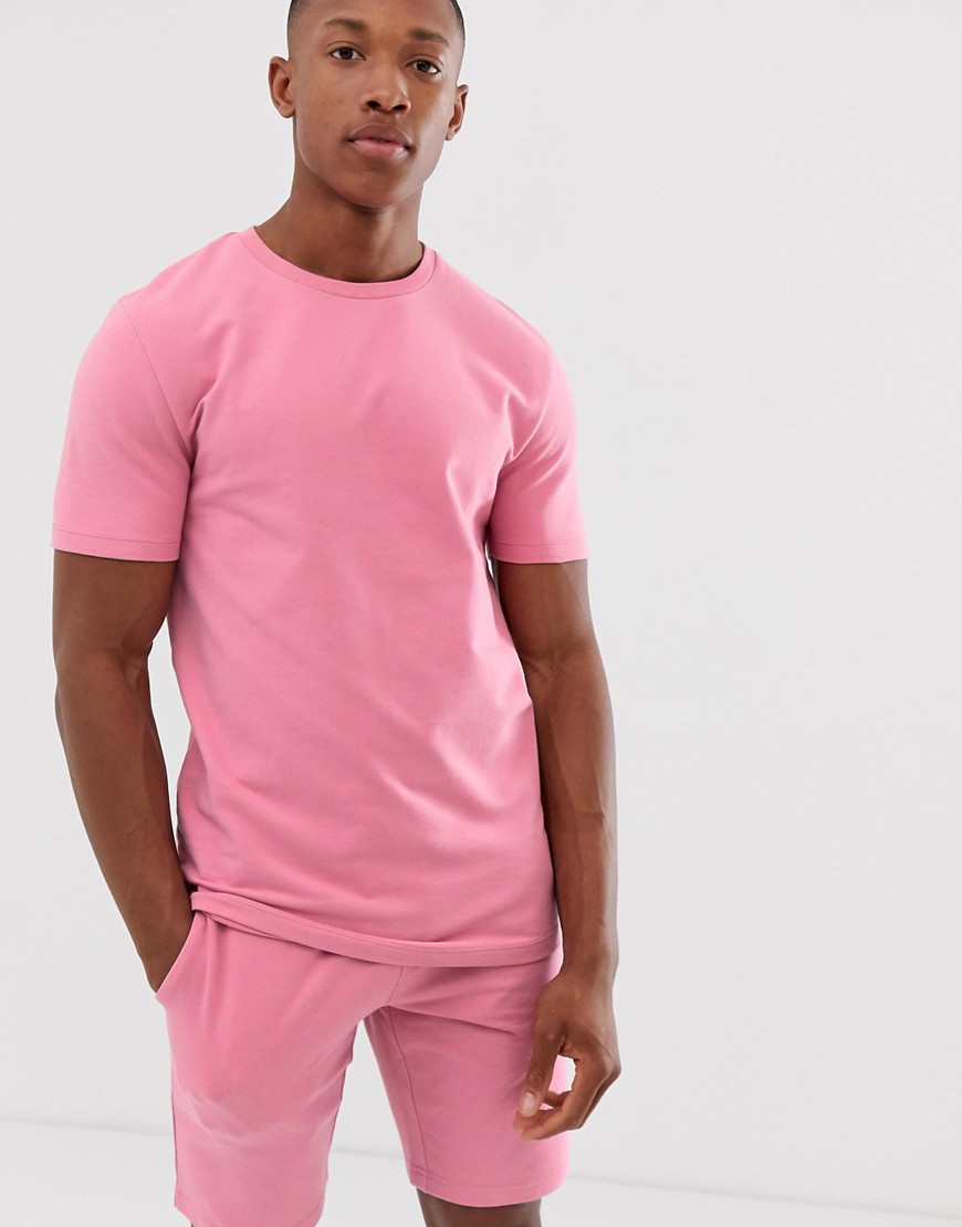 ASOS DESIGN - Tuta sportiva attillata a maniche corte con pantaloncini rosa