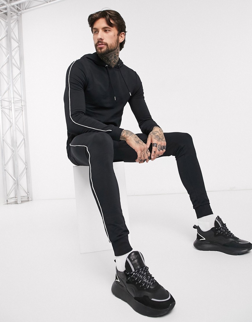 ASOS DESIGN - Tuta sportiva attillata nera con felpa con cappuccio e profili-Nero