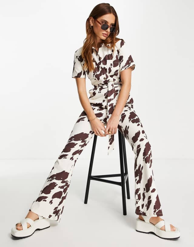 ASOS DESIGN twill 70s kickflare boilersuit in cow print