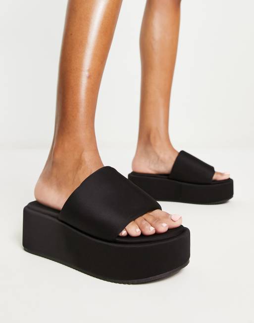ASOS DESIGN – Tyla – Sandalen in Schwarz mit flacher Plateausohle und gepolstertem Riemen 