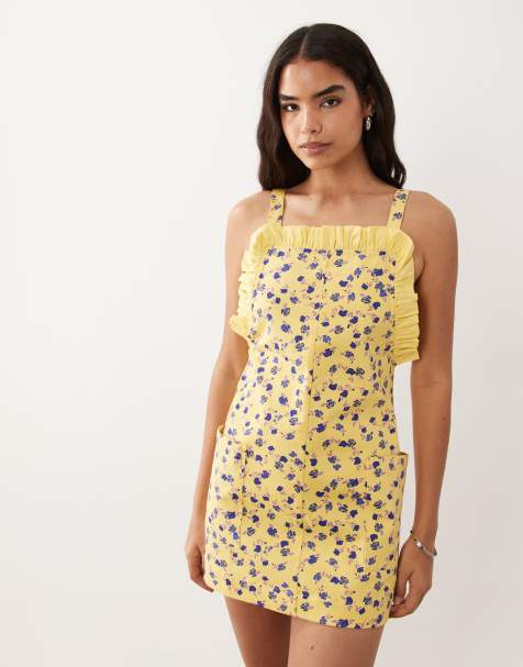 ASOS DESIGN - Vestido corto amarillo estilo pichi con bolsillos, volantes y estampado de florecitas - view 1