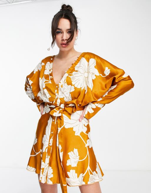ASOS DESIGN - Vestitino in raso giallo senape a fiori con maniche ad ali di pipistrello, bottoni e allacciatura sul davanti 