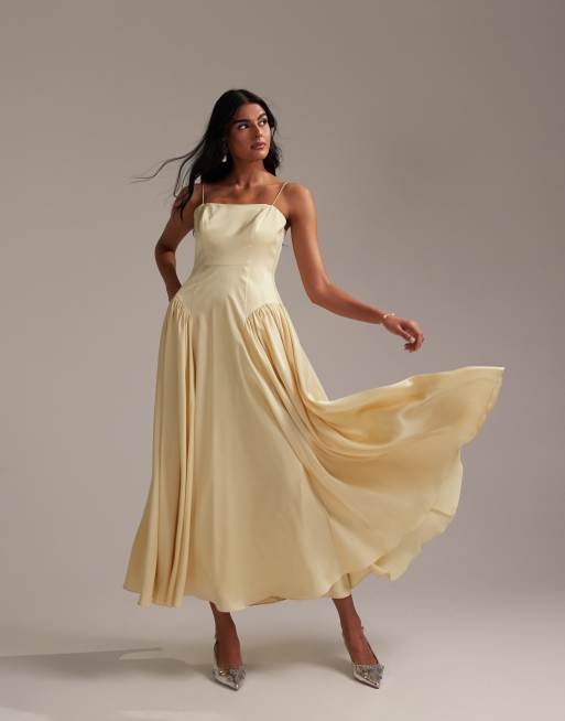 ASOS DESIGN - Vestito da damigella giallo tenue con spalline sottili, gonna al polpaccio, dettagli allacciati e vita scesa