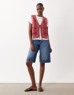 ASOS DESIGN - Wattierte Steppweste in burgunderroter Acid-Waschung mit Blumendesign