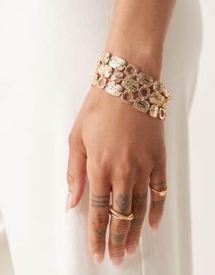 wide bracelet with swirly design in gold tone