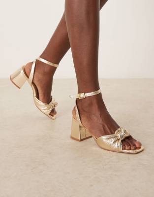 ASOS DESIGN Wide Fit - Hansel - Sandaletten in Gold mit Zierknoten und mittelhohem Absatz, weite Passform-Goldfarben