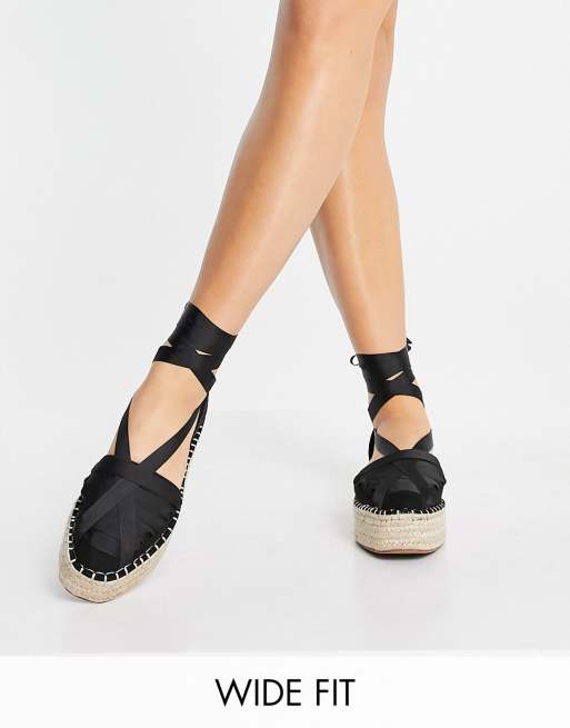 ASOS DESIGN Wide Fit Junior Espadrilles in Schwarz mit flacher Plateausohle und Schnurung am Knochel ASOS