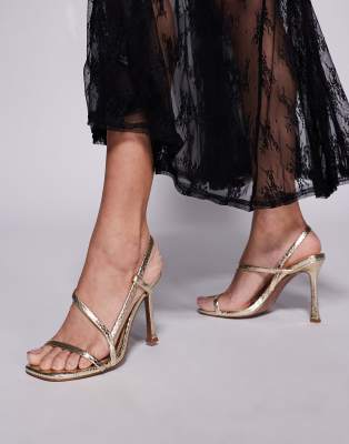 ASOS DESIGN Wide Fit - Nadiya - Filigrane, hohe Sandaletten in Gold mit Fersenriemchen und Schlangenmuster, weite Passfo...