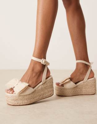 ASOS DESIGN Wide Fit - Tabitha - Sandalen aus natürlichen Materialien mit Keilabsatz und Schleifenverzierung, weite Pass...