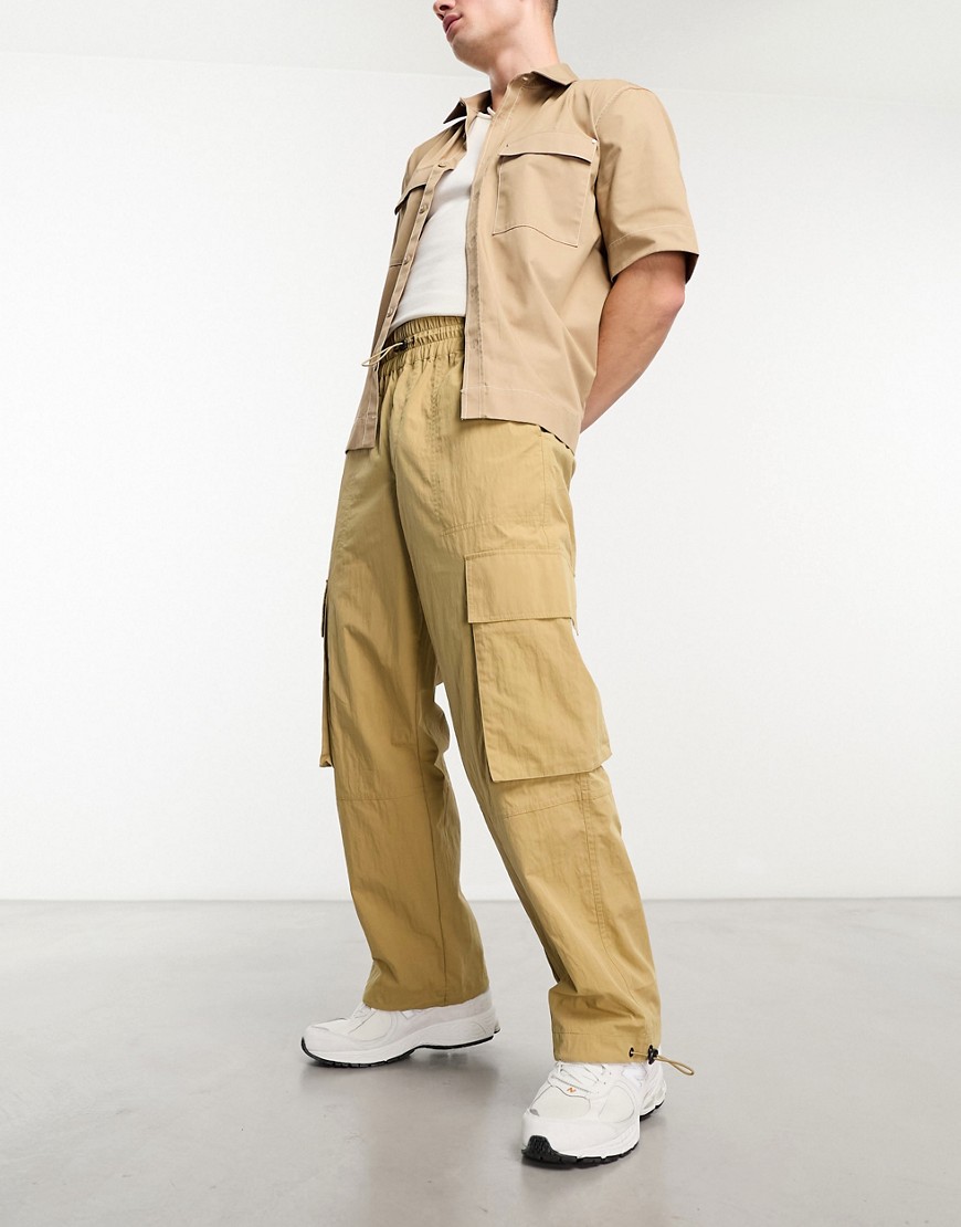 Shop Asos Design Wide Leg Nylon Cargo Pants With Elastic Waist In Beige-neutral