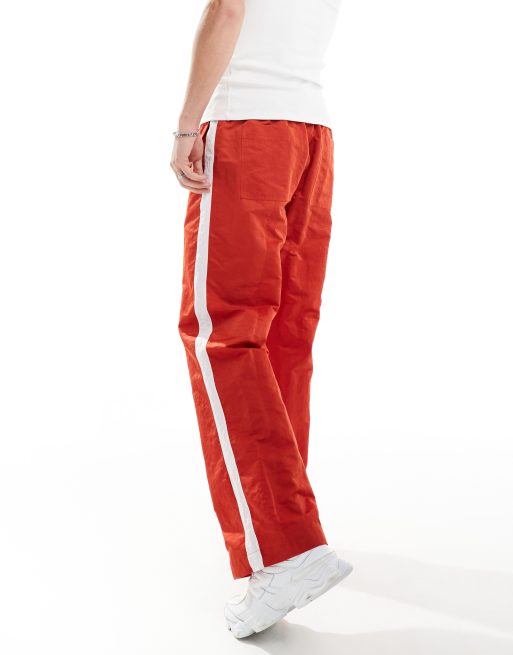 Red track pants with white stripe deals