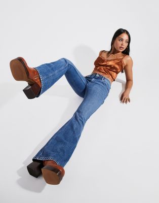 ASOS DESIGN - Wijd uitlopende jeans met stretch en lage taille in midwash |  ASOS