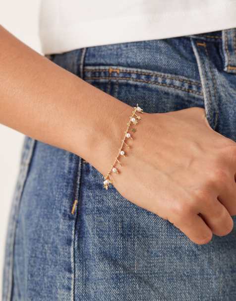 ASOS DESIGN – Zartes, goldfarbenes Kettenarmband mit kleinen Anhängern mit Sternchen und Kunstperlen - view 1