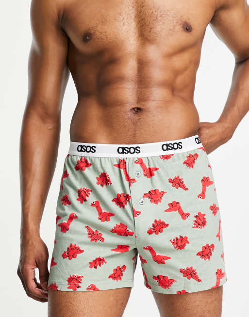 ASOS DESIGN – Zielone szorty bokserki w czerwony kreskówkowy wzór w dinozaury