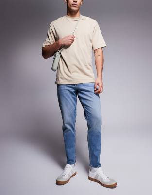 ASOS DSIGN stretch tapered jeans in mid wash with vintage tint - view 1