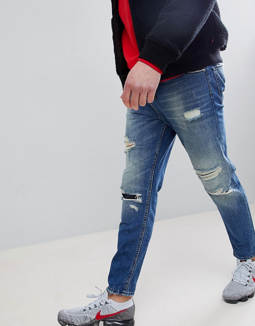 ASOS - Jeans met smaltoelopende pijpen en scheuren in blauwe mid-wash