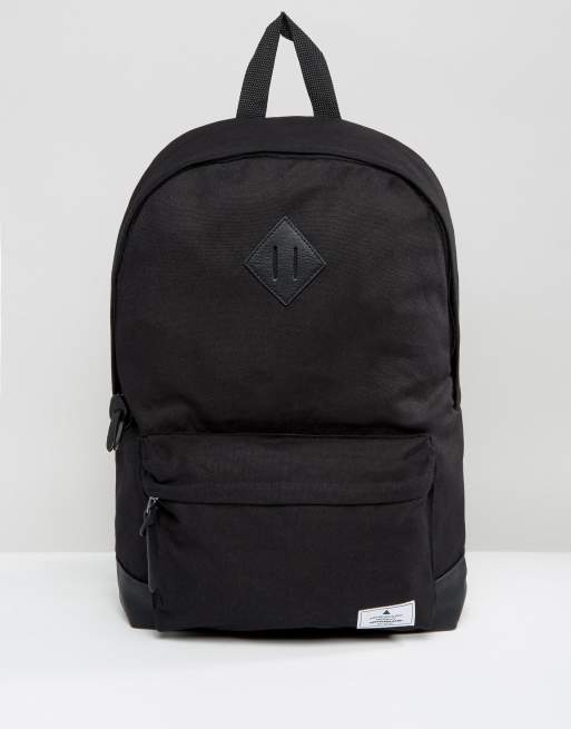 ASOS Unrvlld Spply backpack in black canvas with faux- leather base and branded patch