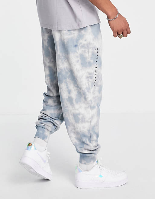 ASOS Unrvlld Spply co-ord relaxed joggers with all over wash & logo print in blue