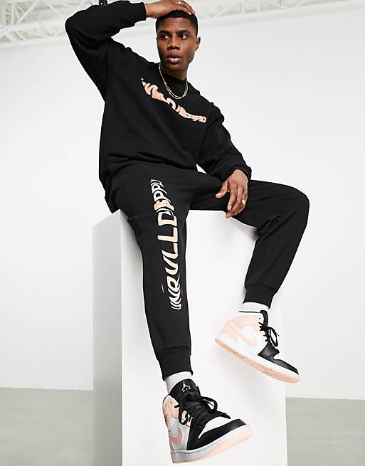 ASOS Unrvlld Spply relaxed sweatpants with logo leg print in black - part  of a set | ASOS