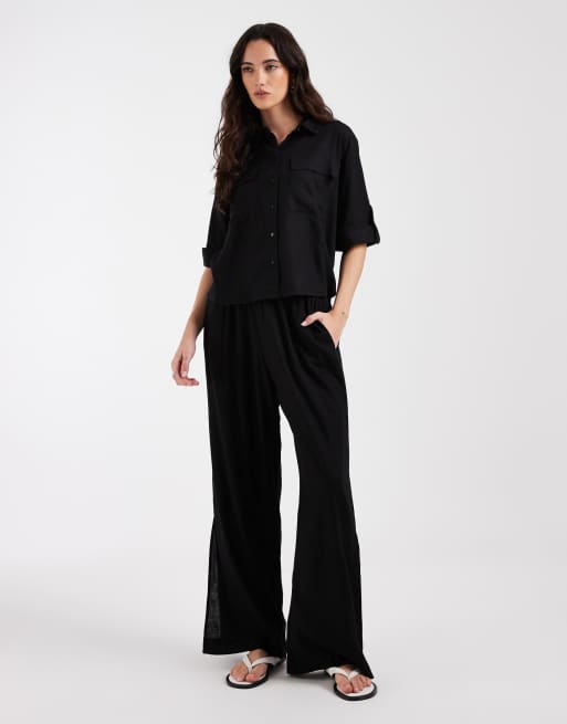 AWARE - Completo con camicia stile safari e pantaloni a fondo ampio in misto lino nero con dettagli sulle maniche