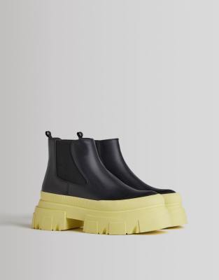 BERSHKA CHUNKY FLAT CHELSEA BOOT WITH CONTRAST YELLOW SOLE IN BLACK