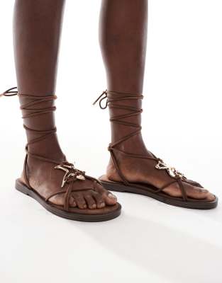 Bershka - Flache, geschnürte Sandalen in Braun mit goldener Verzierung