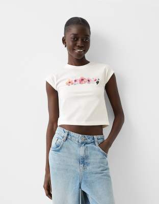 Bershka - Knapp geschnittenes T-Shirt in Ecru mit Vintage-Blumengrafik-Bunt