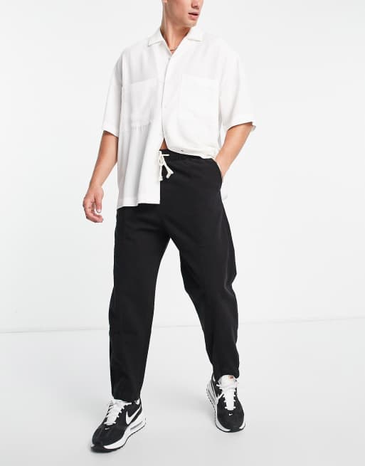 Bershka – Locker geschnittene Hose in Schwarz mit Bahnendesign