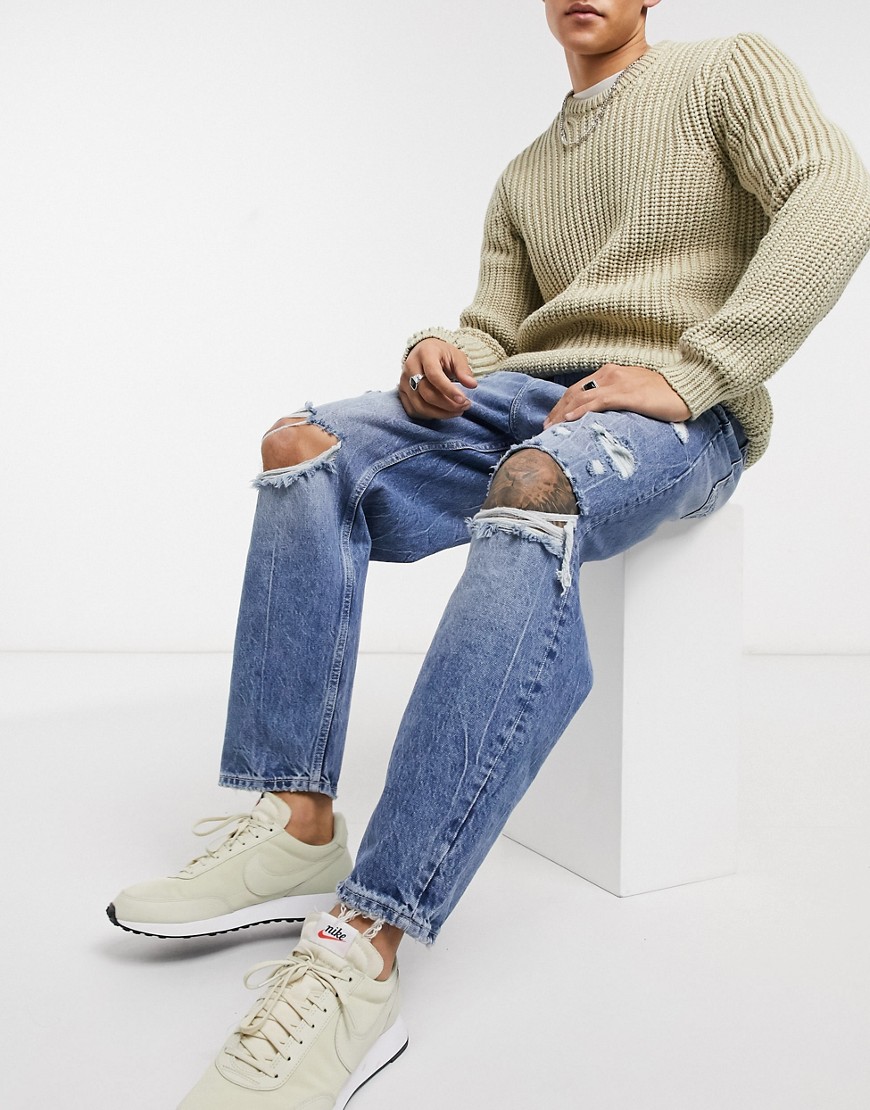 Bershka - Losvallende jeans met scheuren in middenblauwe wassing