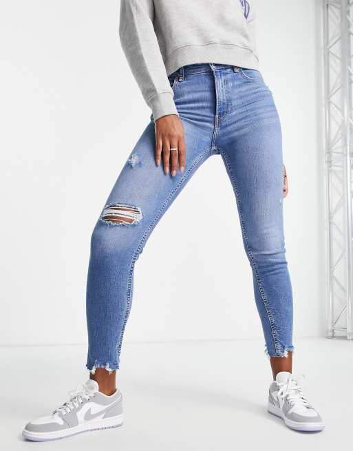 Bershka low waist skinny jean with rips in medium blue | ASOS