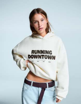 Bershka - Oversize-Kapuzenpullover in Ecru mit Aufdruck-Weiß