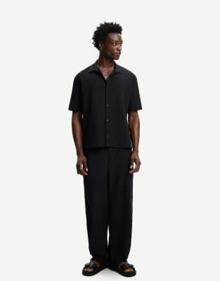 Bershka pleated baggy jogger trousers in black - view 1