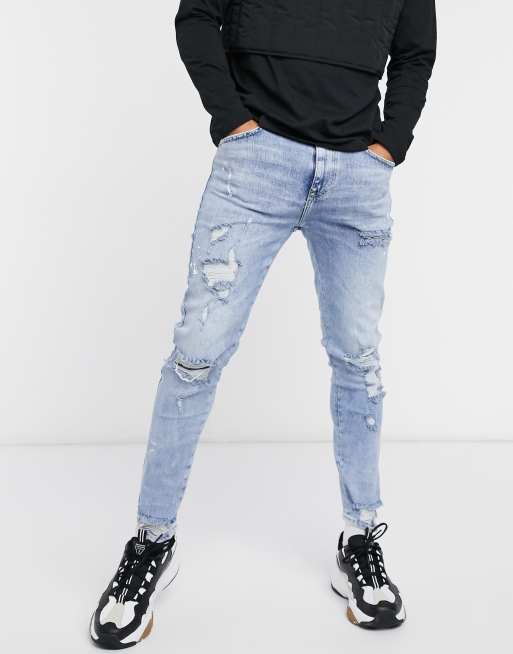 Bershka skinny jeans with rips & paint splatter in blue | ASOS