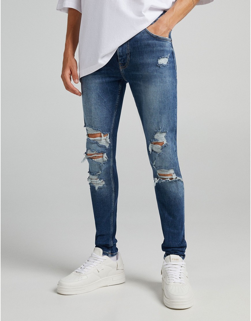 Bershka super skinny jeans with rips and frayed hem in blue-Blues