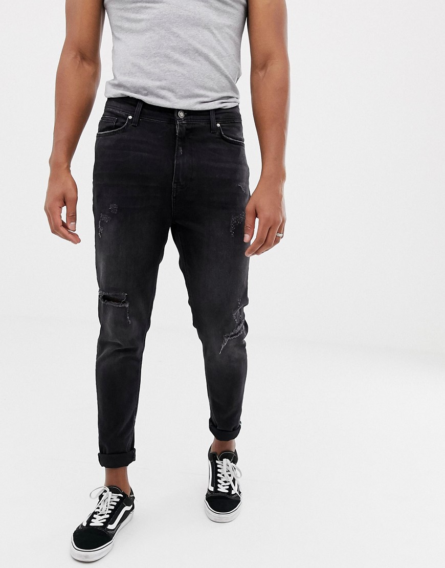 Bershka tapered carrot fit jeans in black with rips and hem taping