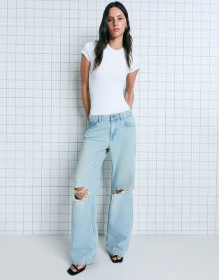 Bershka - Weite Jeans in Mittelblau mit Rissen