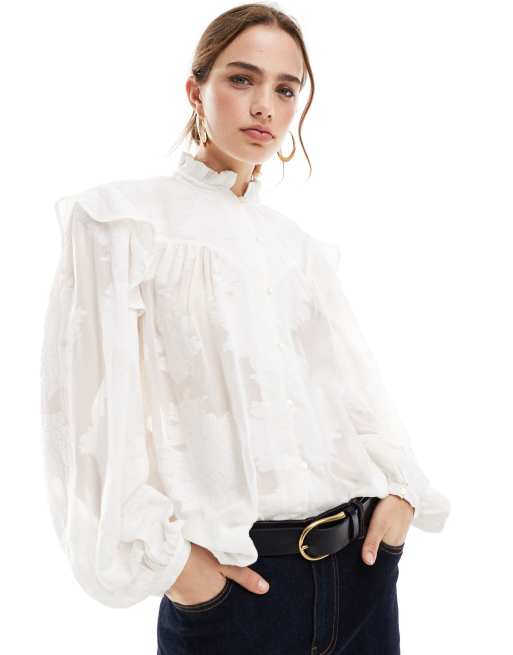 Blusa blanco hueso con volante en los hombros y cuello alto de Mango