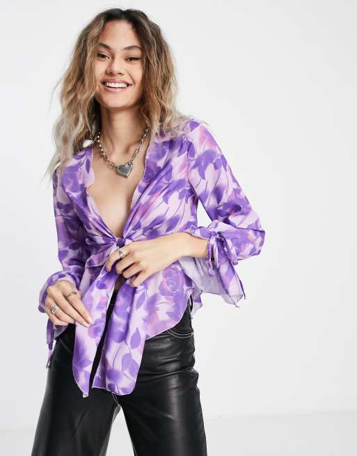 Blusa de flores violeta con detalle de volantes y lazada delantera