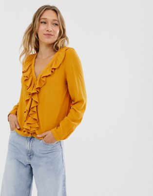 фото Блузка горчичного цвета с v-образным вырезом и оборками monki-желтый